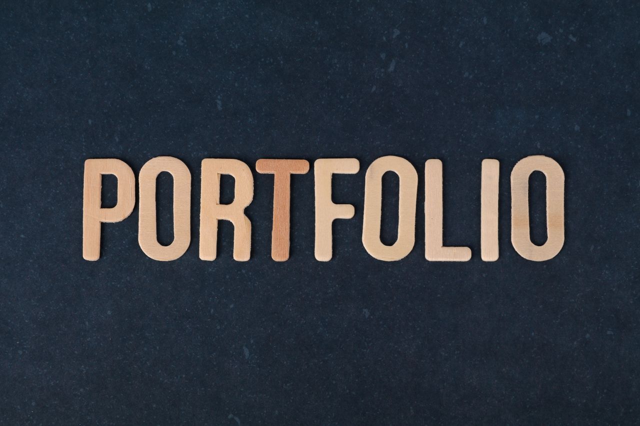 Wooden letters spelling the word portfolio on a textured black background, ideal for creative projects.